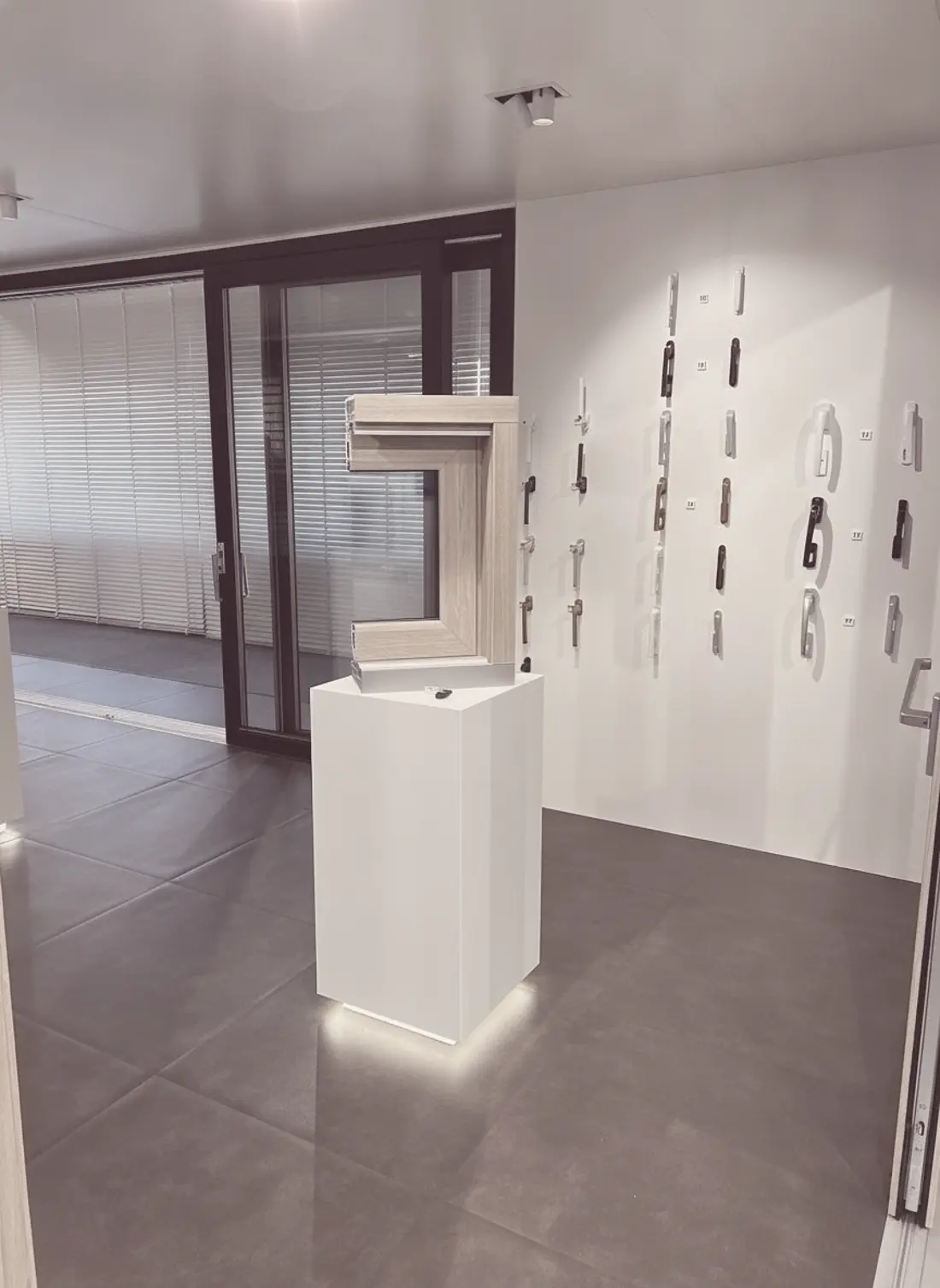 Profilmuster auf einem Podest, dahinter eine Wand mit Griffen und eine große Schiebetür